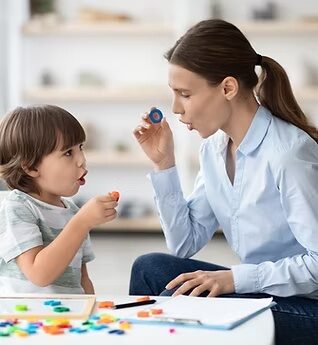 Speech pathologist supporting a child during a therapy activity