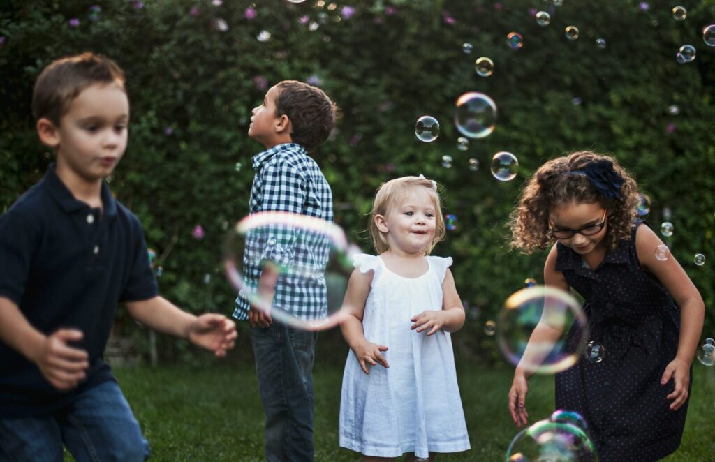 Children surrounded by bubbles outdoors
